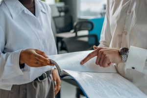 two professionals pass a document between themselves